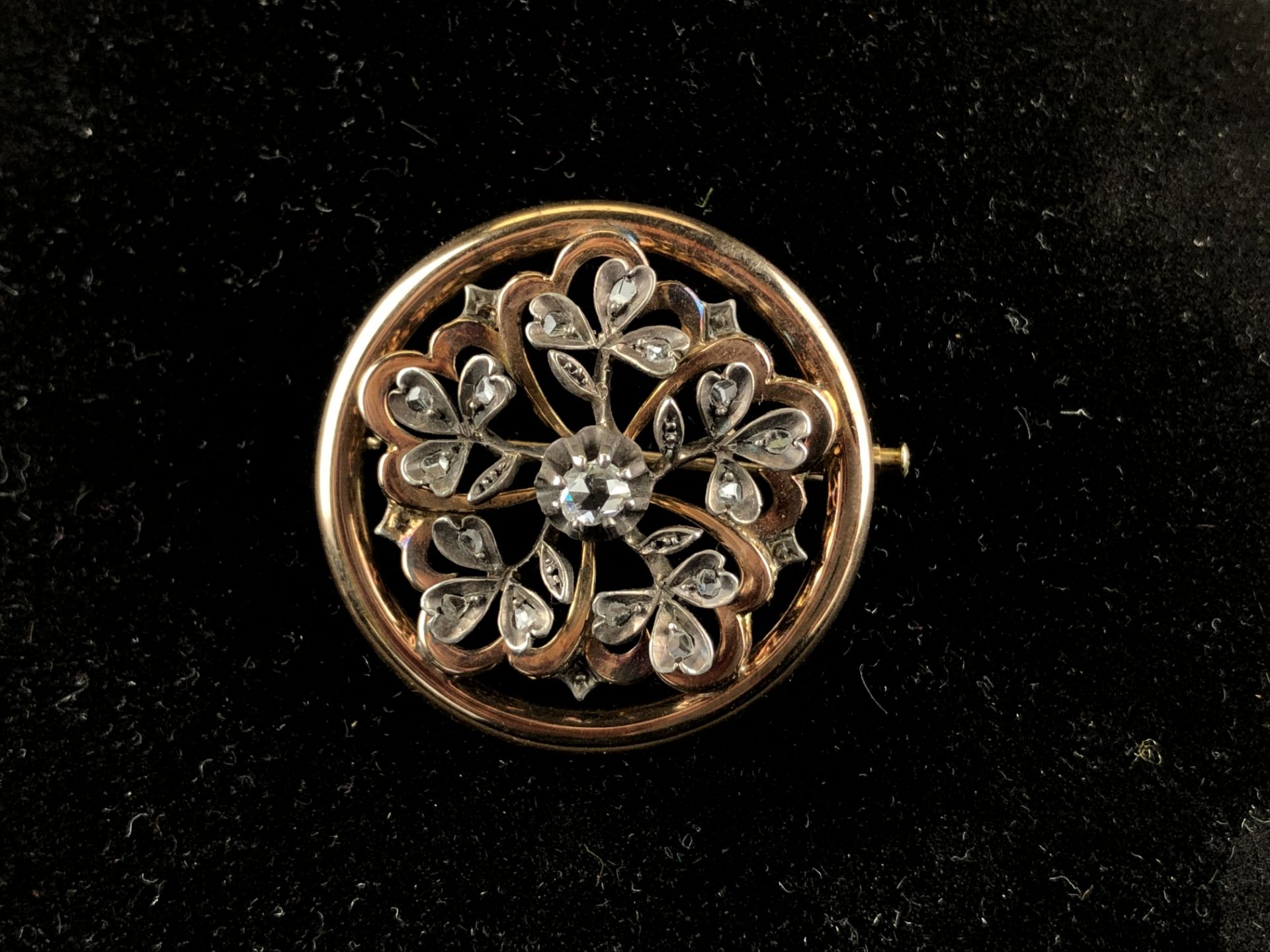 Broche ronde ajourée en or et argent, à motif de fleurs. P. 9,97 g. -