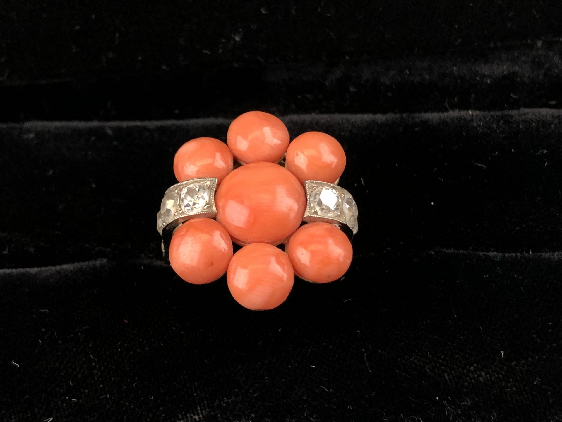 Fabrice LECANU. Bague en or jaune forme fleur sertie de corail en cabochon et de deux [...]