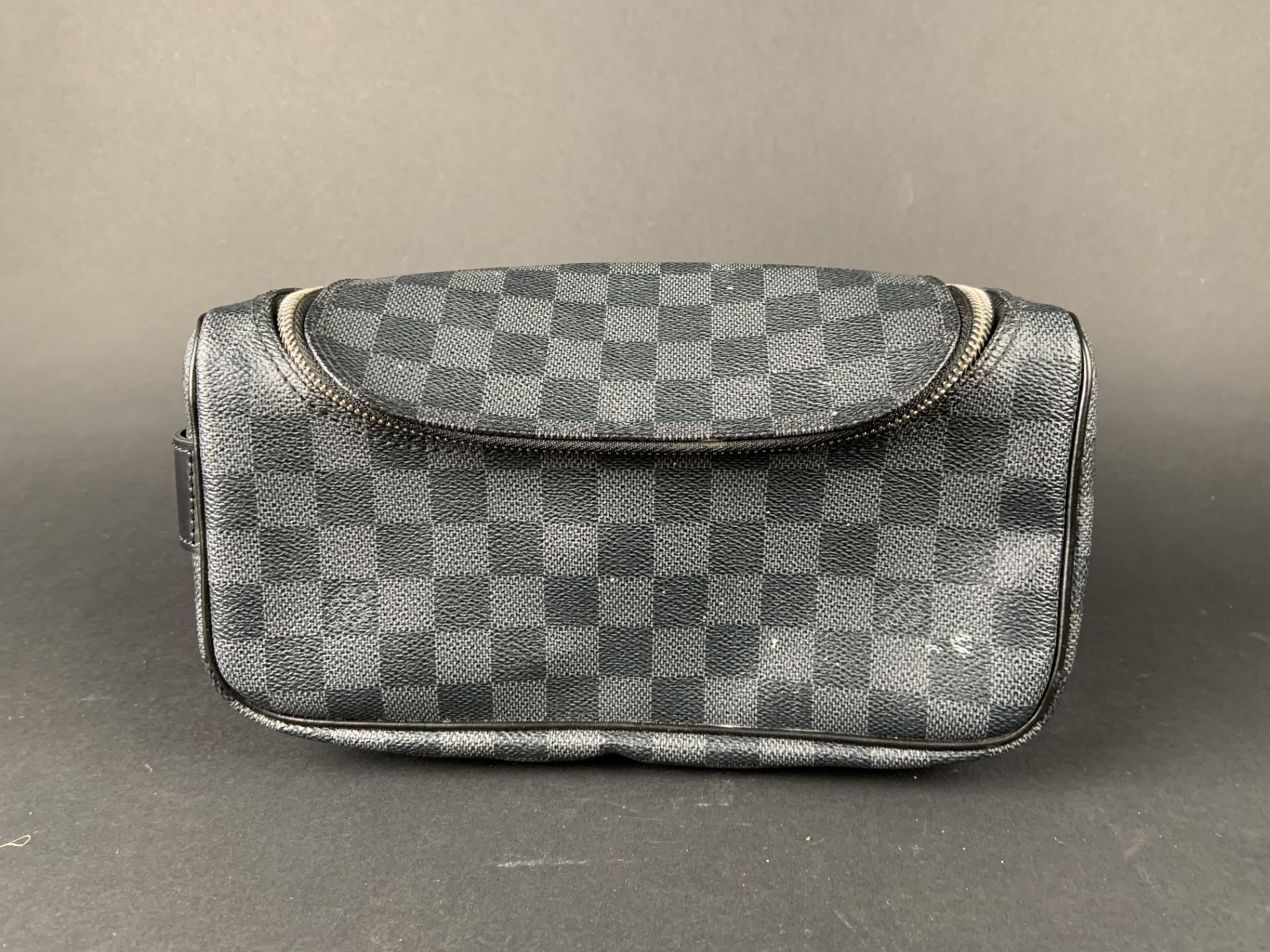 LOUIS VUITTON. Trousse de toilette en toile enduite damier graphite et cuir noir, [...]