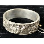 Bracelet rigide articulé en argent ciselé, décor de fleurs. P. 36,5 g. Début XXe [...]