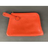 DELVAUX. Pochette porté main, cuir grainé rouge avec une anse. -