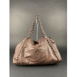 CHANEL. Sac modèle "Grand Shopping" cuir souple marron à décor du monogramme [...]