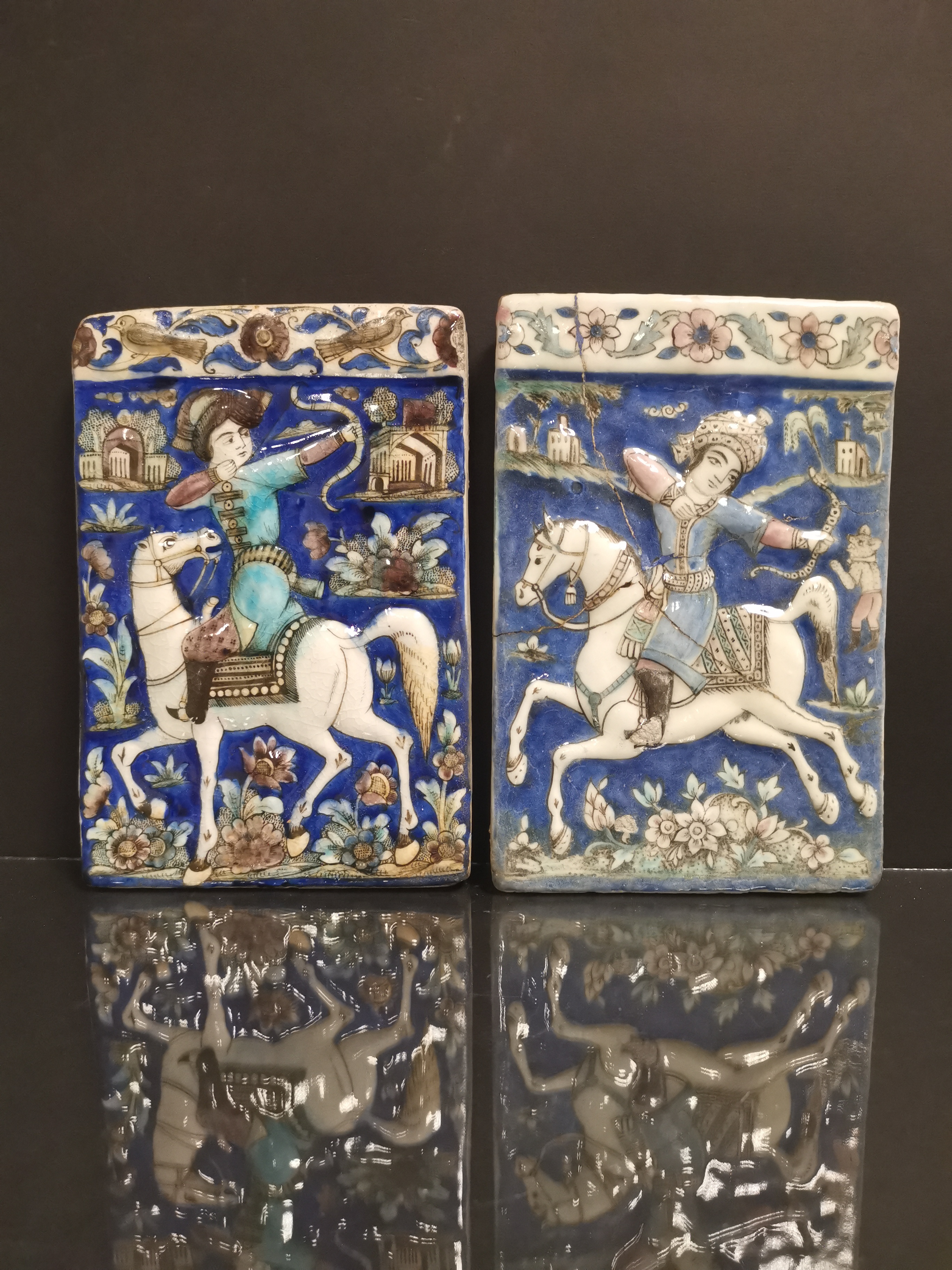 IRAN - Kadjar. Carreau à décor en léger relief d'un archer à cheval sur fond bleu [...]