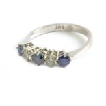 A five stone ring with an 18 k. white gold setting and round brilliant cut diamonds and sapphires