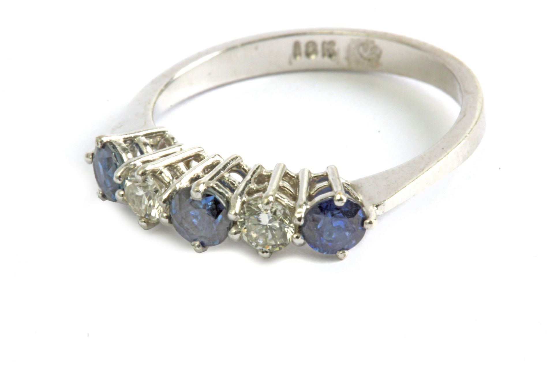 A five stone ring with an 18 k. white gold setting and round brilliant cut diamonds and sapphires