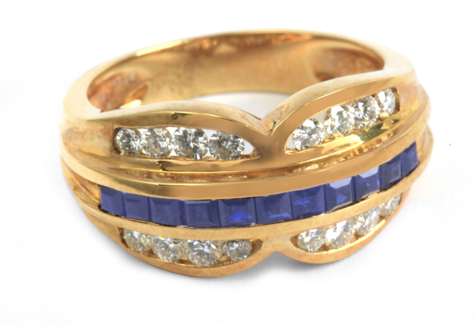 An 18 k. yellow gold ring with round brilliant cut diamonds and carre cut sapphires