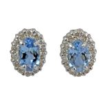 A pair of stud earrings with an 18 k. white gold setting, a moval cut aquamarine