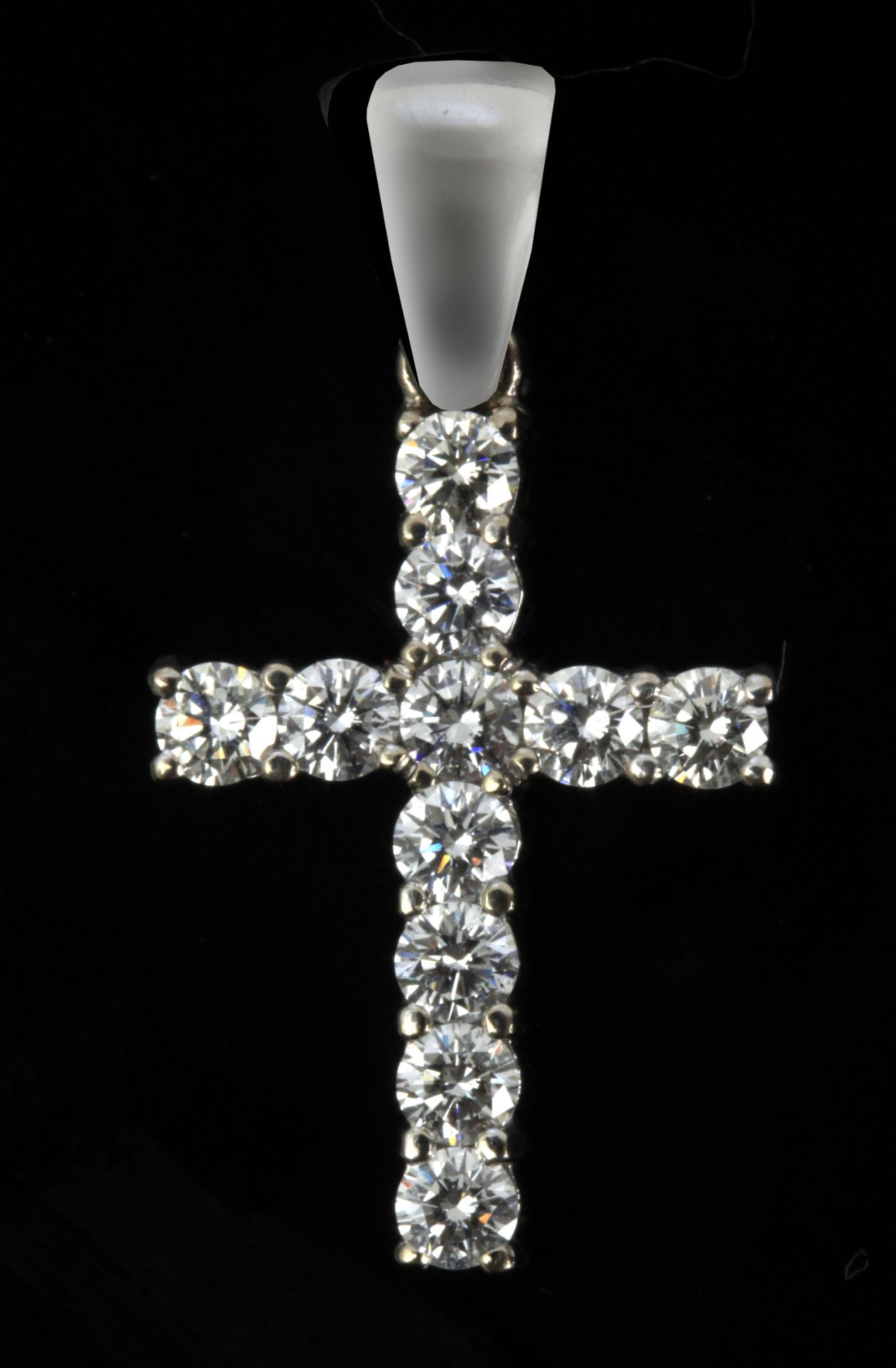 A pendant cross with an 18 k. white gold setting and round brilliant cut diamonds