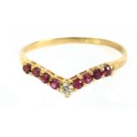 A round brilliant cut diamond and single cut rubies ring with an 18k. yellow gold setting