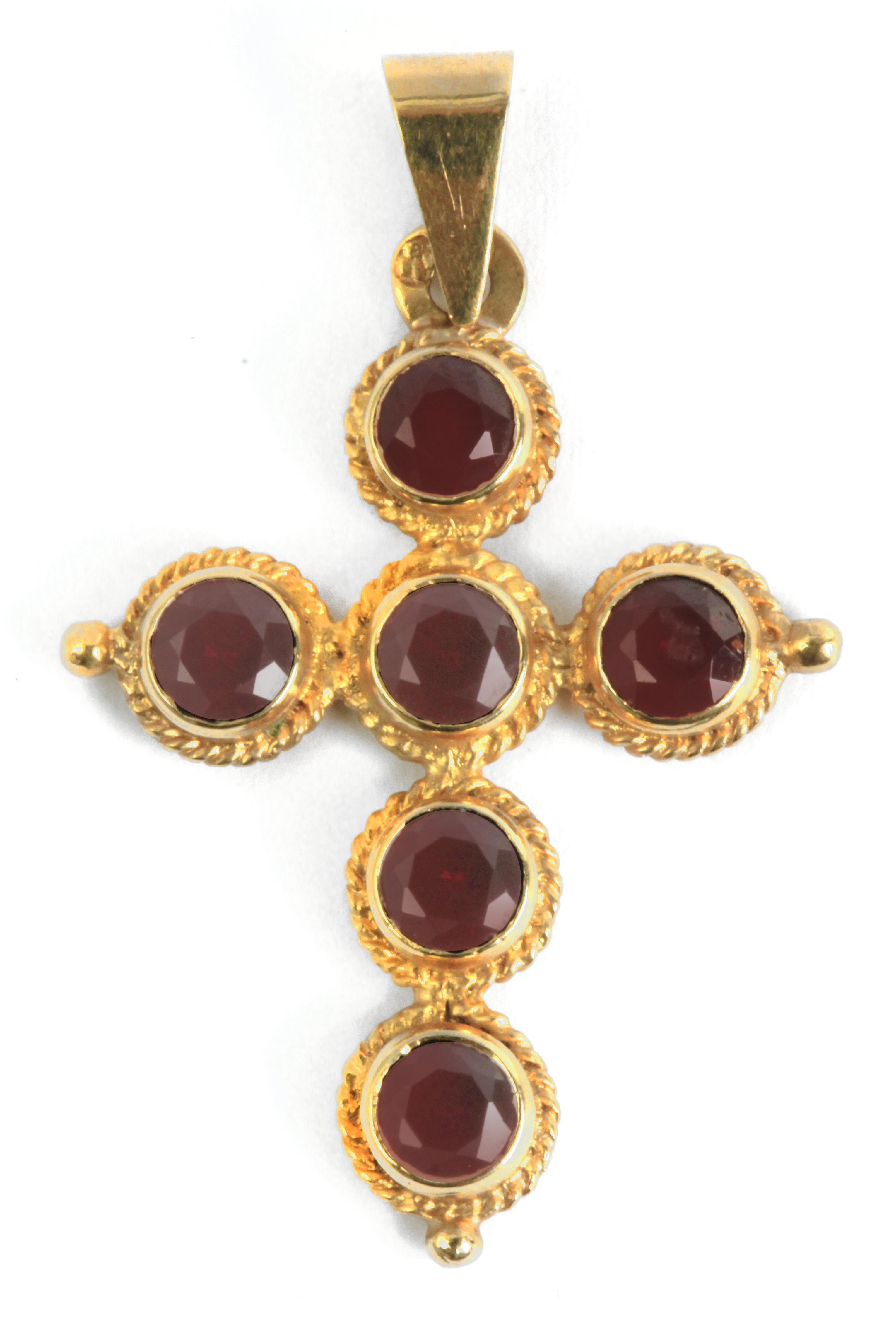 A pendant cross with an 18k. yellow gold setting and round brilliant cut almandine garnets