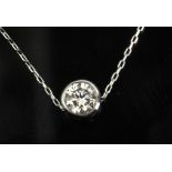 A 0,20 ct. round brilliant cut diamond bezel solitaire pendant with a plantinum setting and chain