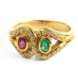 An 18 k. yellow gold ring with and oval cut emerald and ruby and single cut diamonds