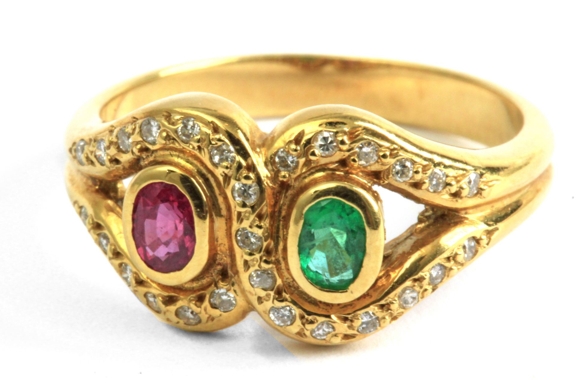 An 18 k. yellow gold ring with and oval cut emerald and ruby and single cut diamonds