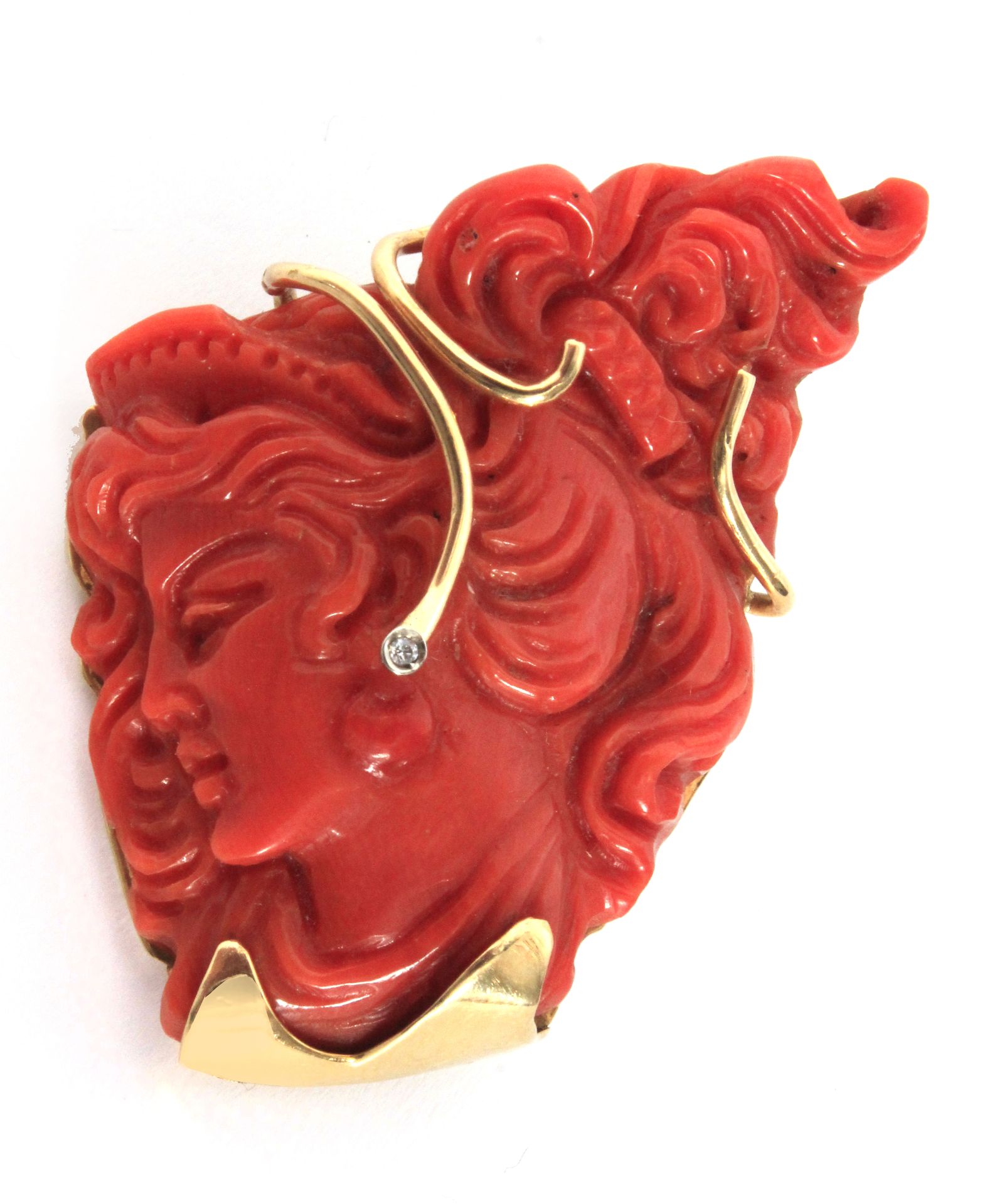 A carved red coral from the Mediterranean Sea root pendant with an 18 k. yellow gold setting