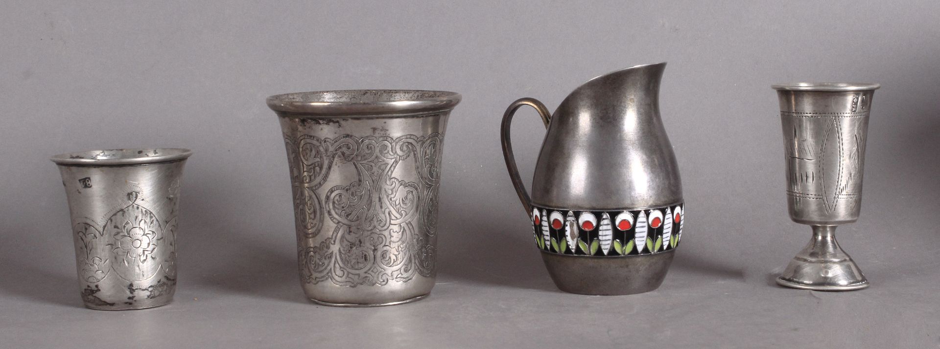 Three Russian silver vodka cups and a milk jug from 19th-20th centuries