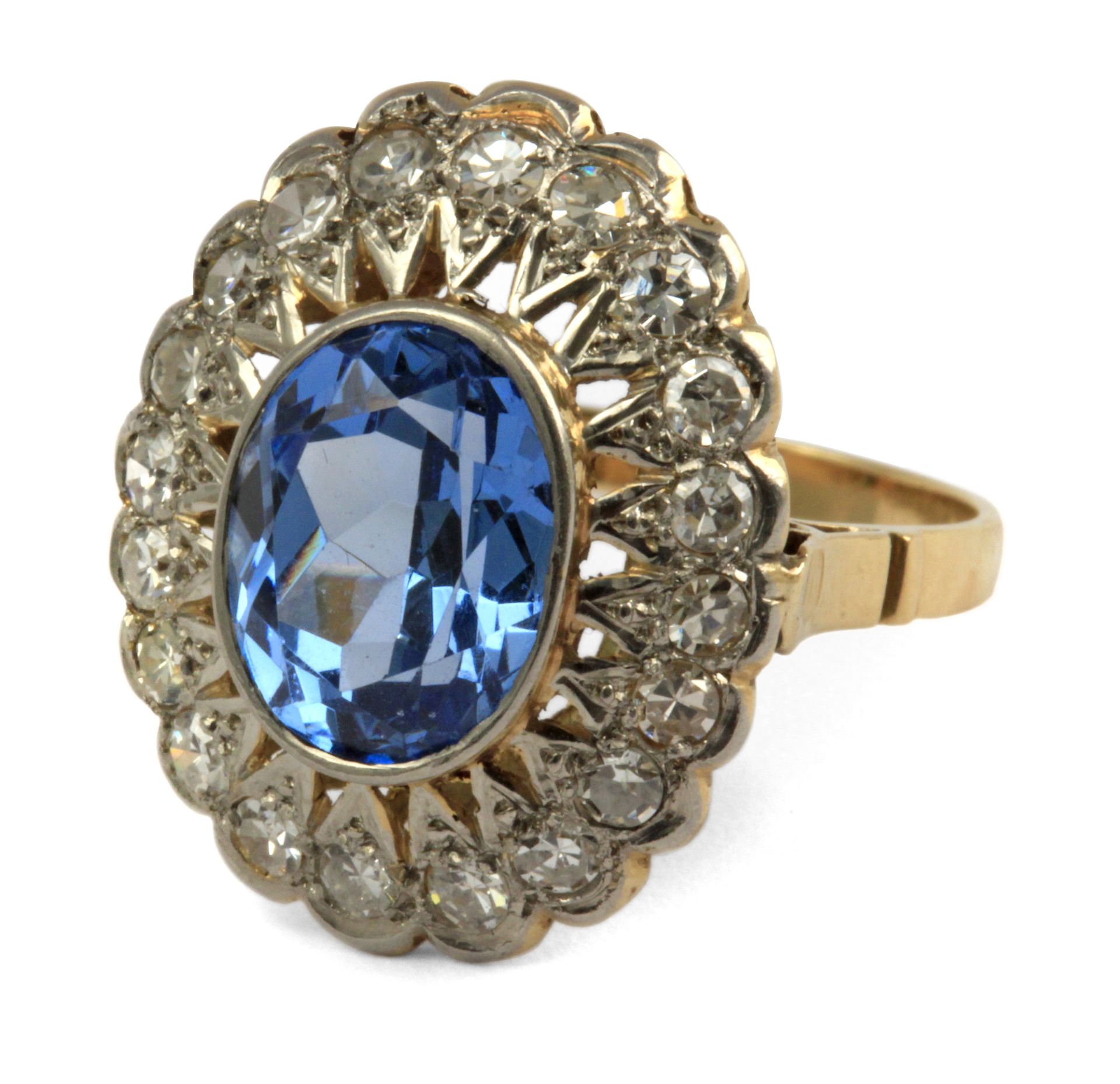 A blue topaz and brilliant cut diamonds cluster ring with an 18 k. yellow gold and platinum setting