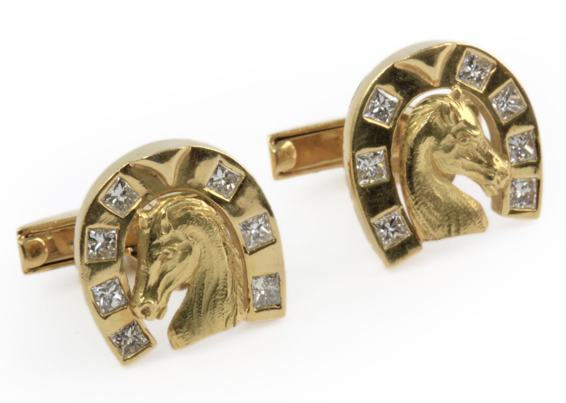 A pair of horseshoe cufflinks. 18 k. yellow gold setting and princess cut diamonds