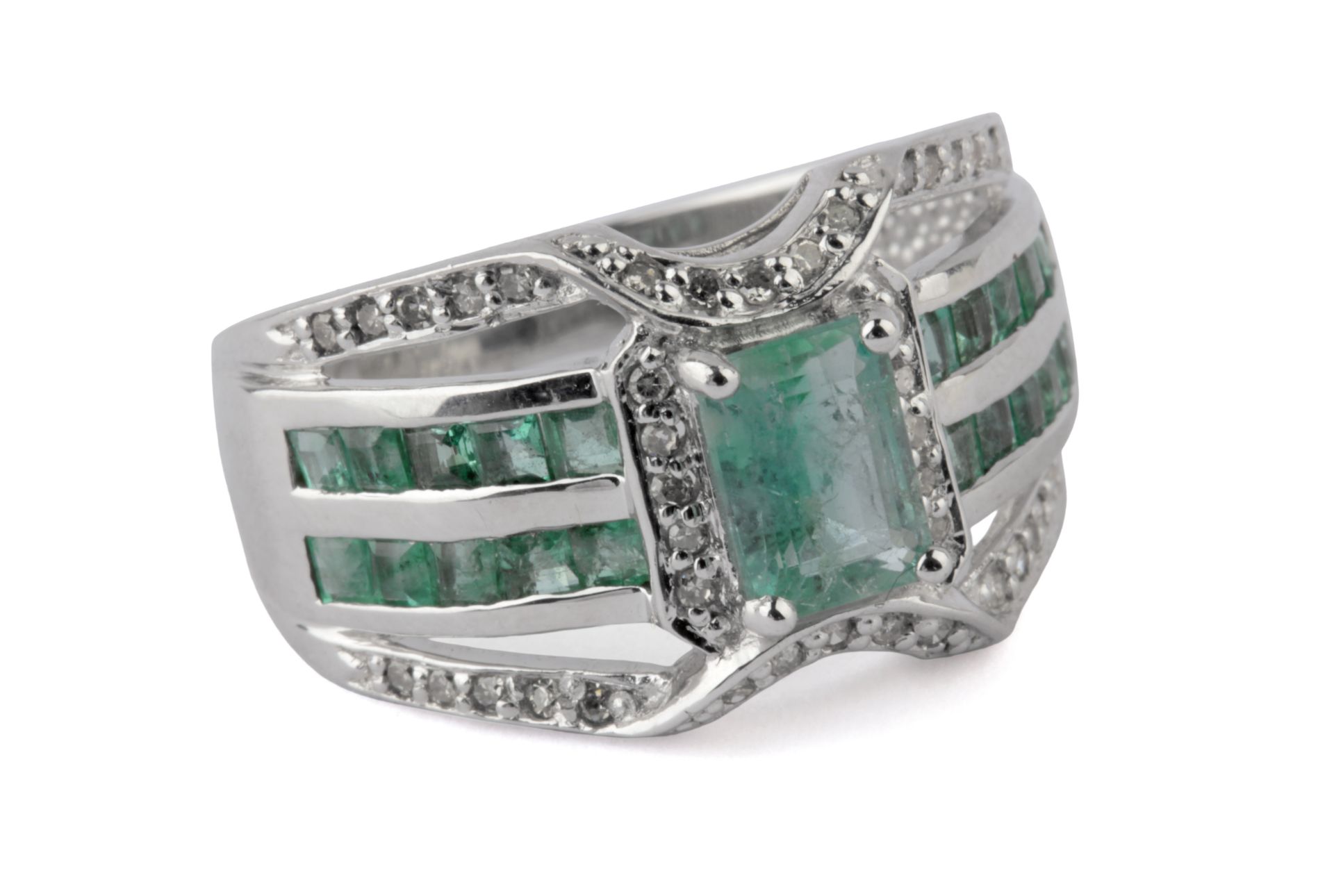 An emerald and diamond ring with an 18 k. white gold setting