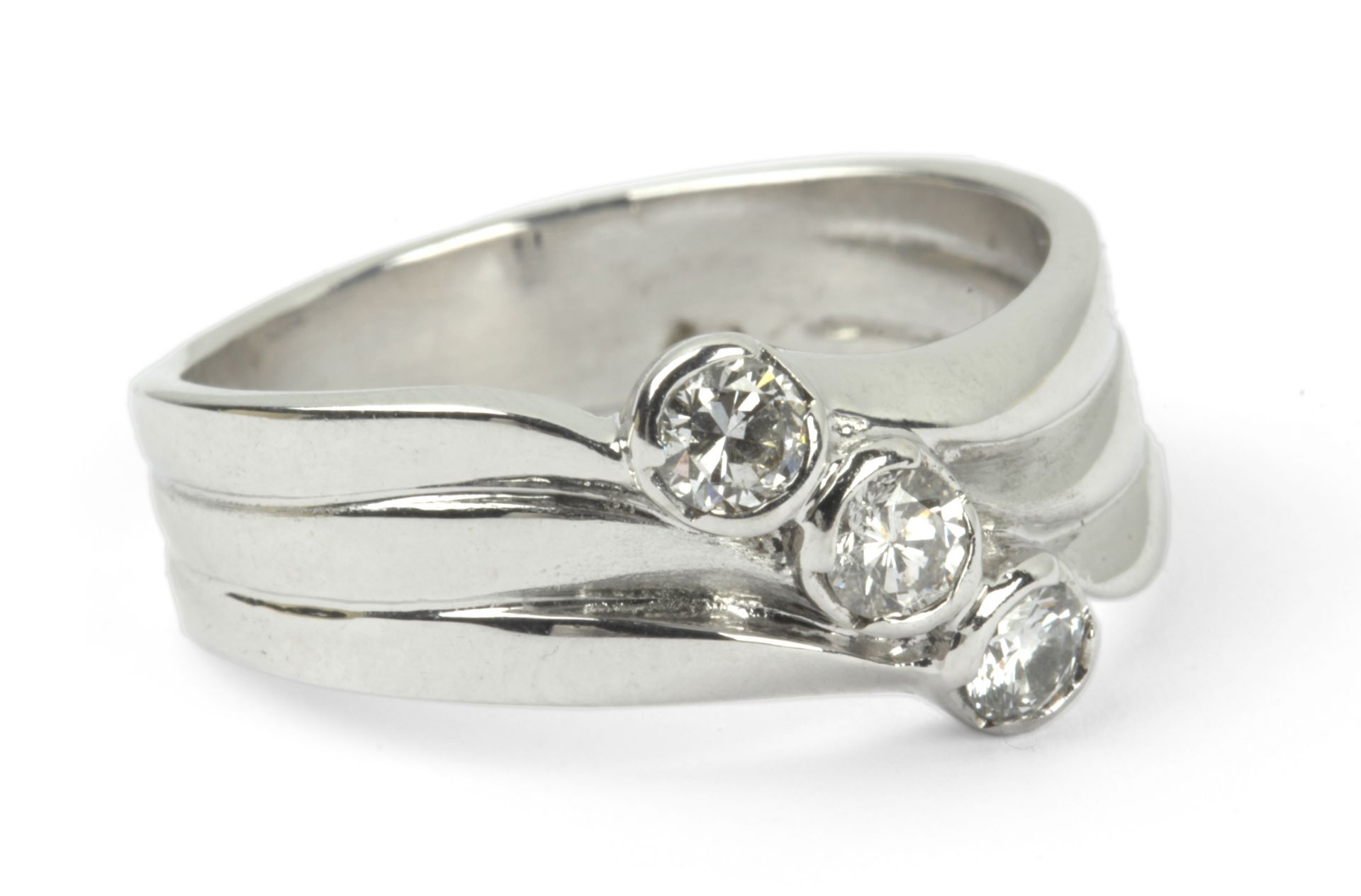 A three stone diamond ring with an 18 k. white gold setting