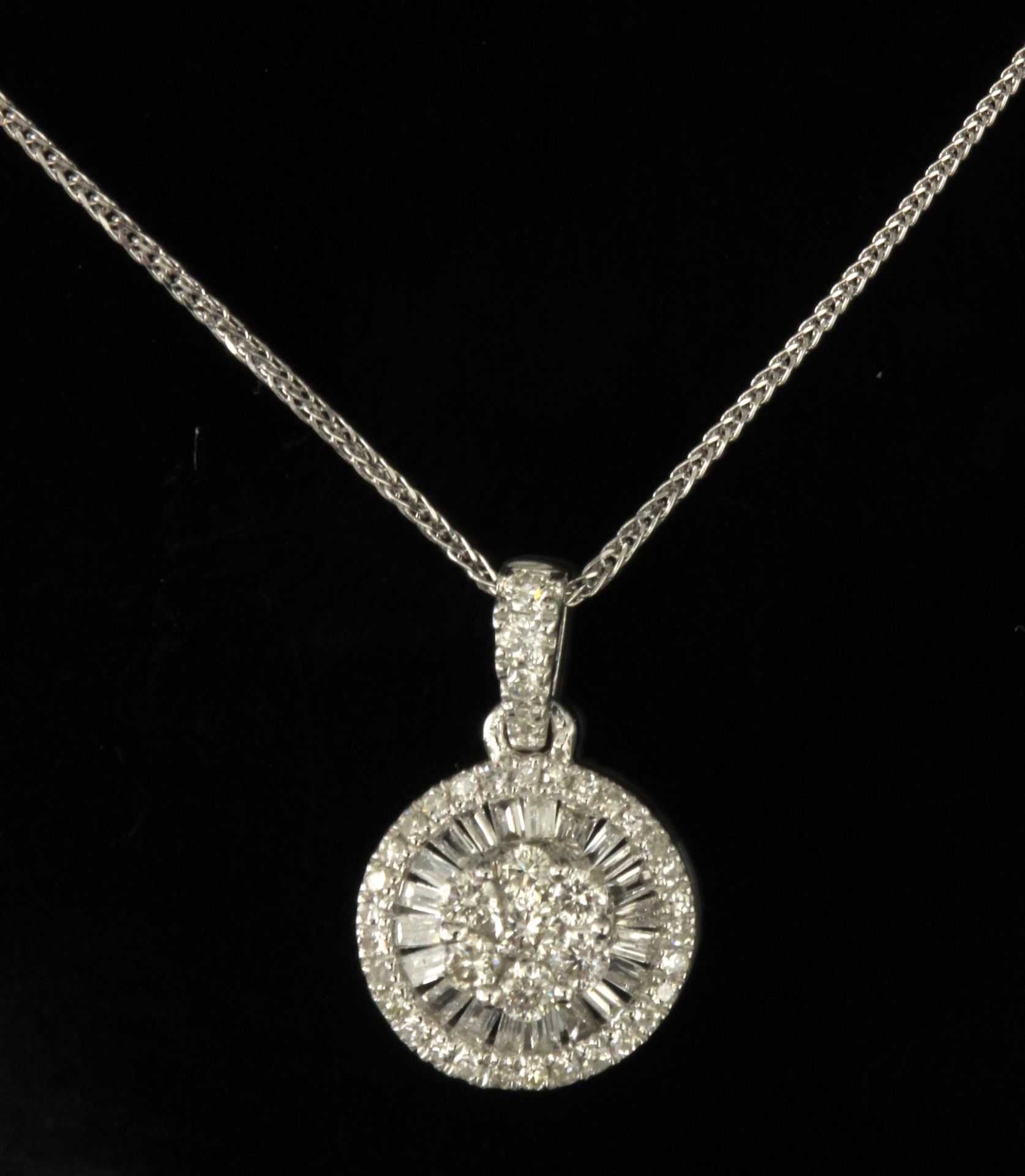 A diamond cluster pendant with an 18 k. white gold setting and chain