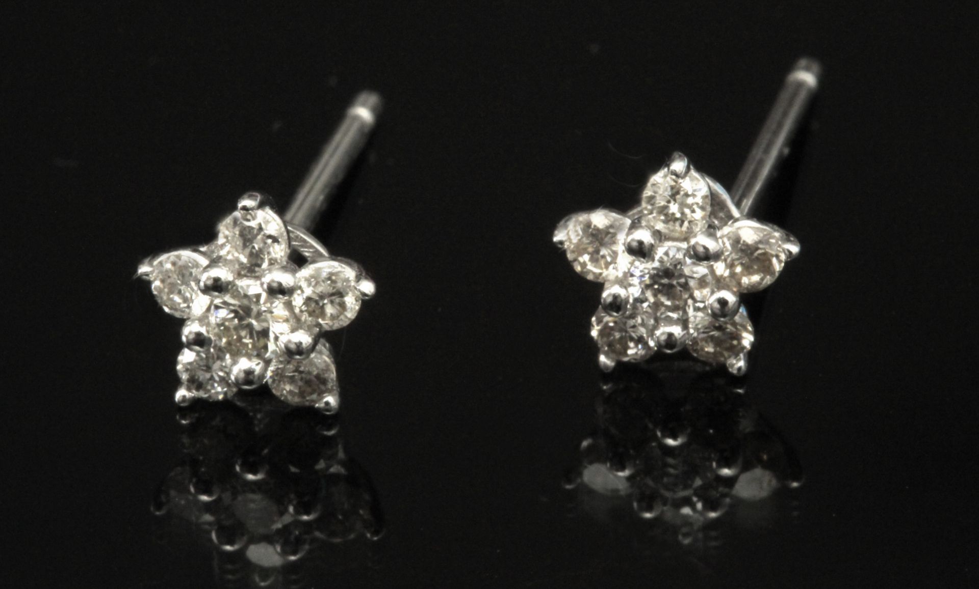 A pair of brilliant cut diamond star shaped stud earrings in an 18 k. white gold setting