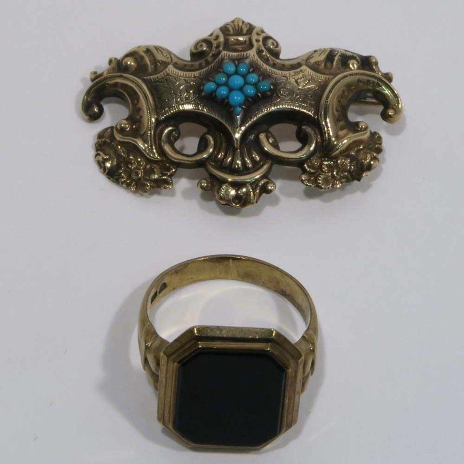 Brosche und Ring8 K GG, Marke (333) bzw. Schaumgold. Ring mit Onyx-Platte, Brosche mit Türkisen.