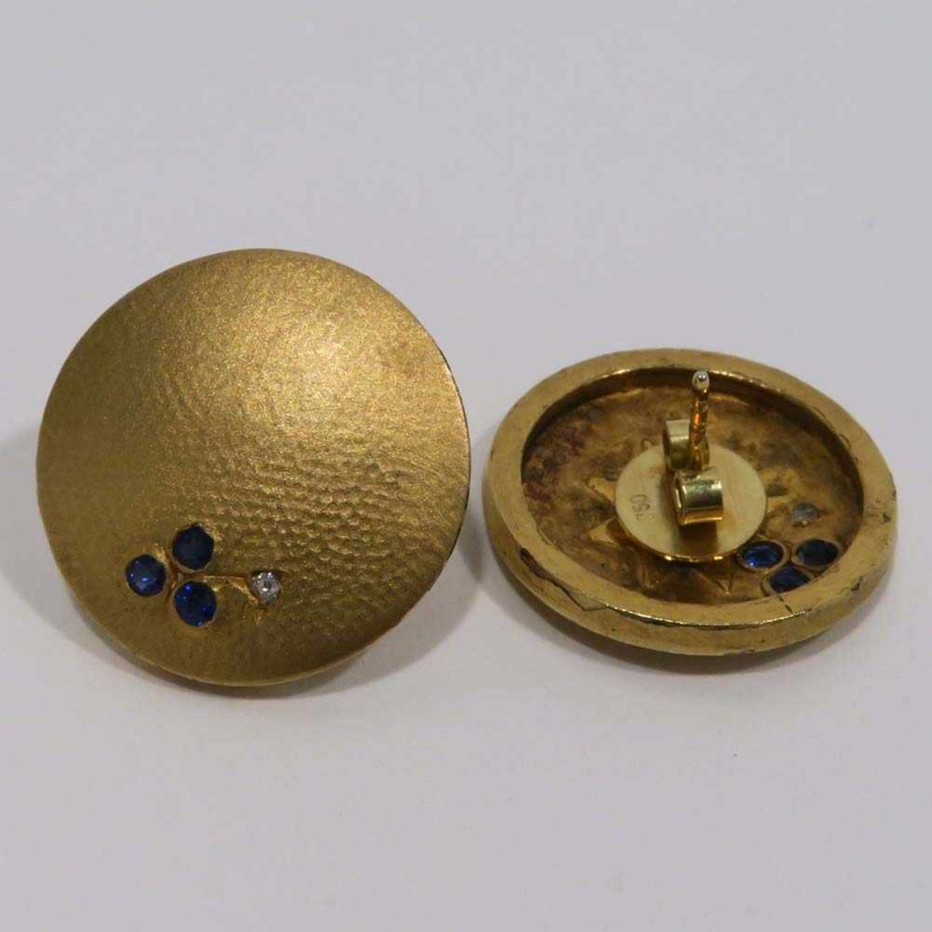 Paar Ohrstecker18 K GG. Rund mit je drei kleinen Saphiren und einem Kleindiamant. Ø 21,5 mm. Zus.