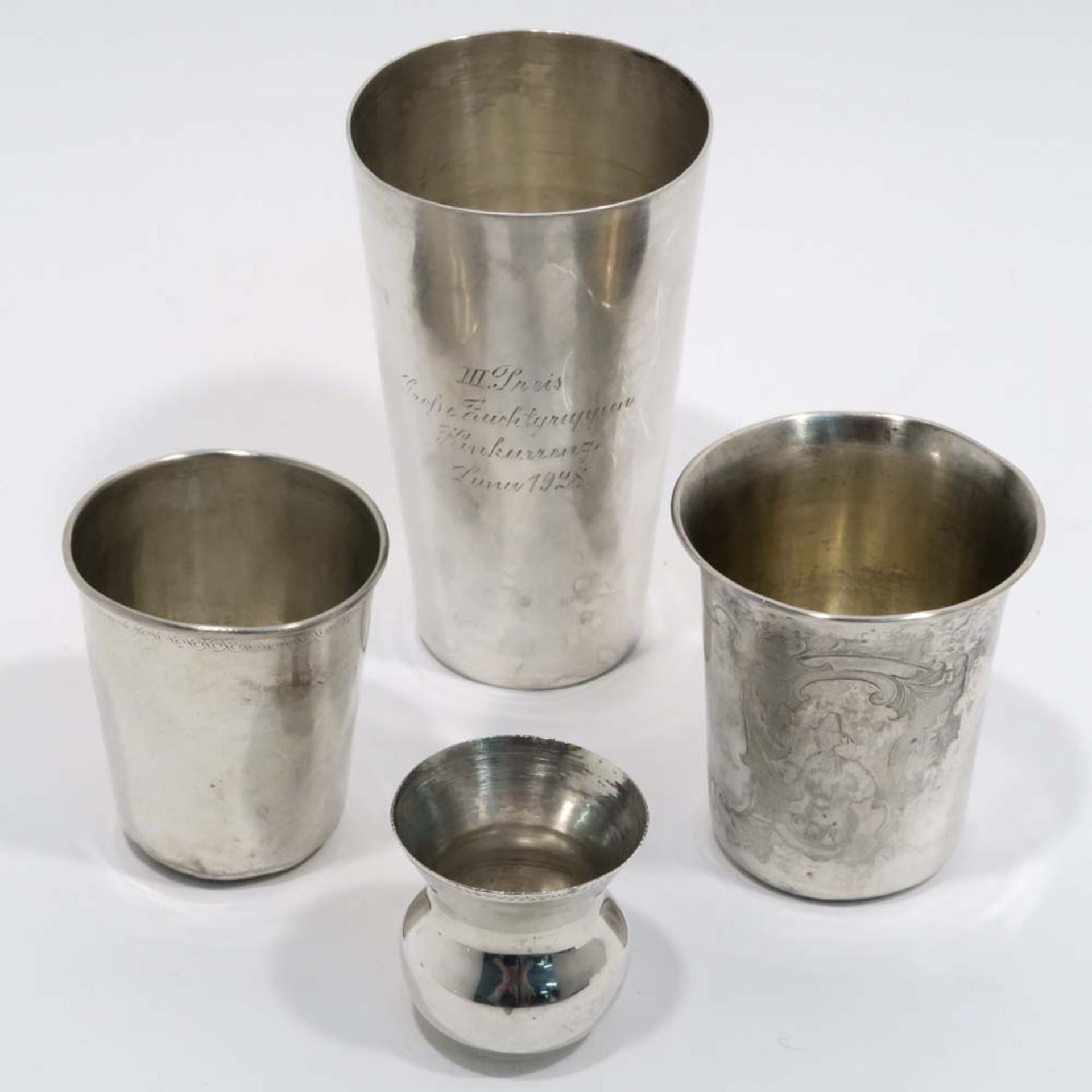 Vier Becher19. bzw. 20. Jh. Silber. Verschiedene Formen, zwei Becher graviert: figürlicher Dekor