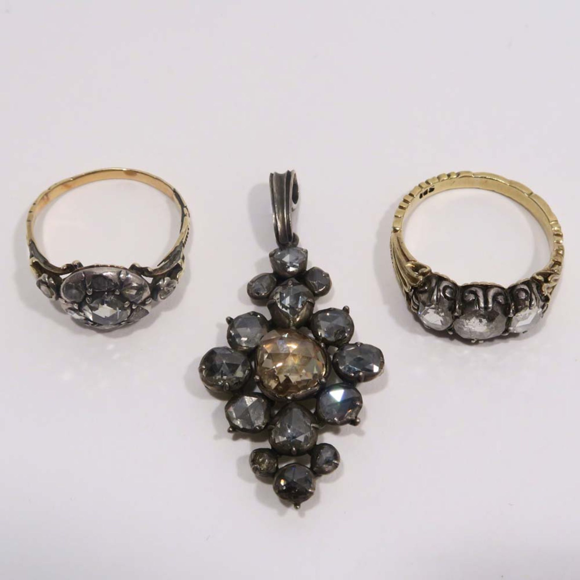 Zwei Ringe und ein Anhänger14 K GG, tlw. Marke (585), bzw. Silber. Mit Diamantrosen besetzt.