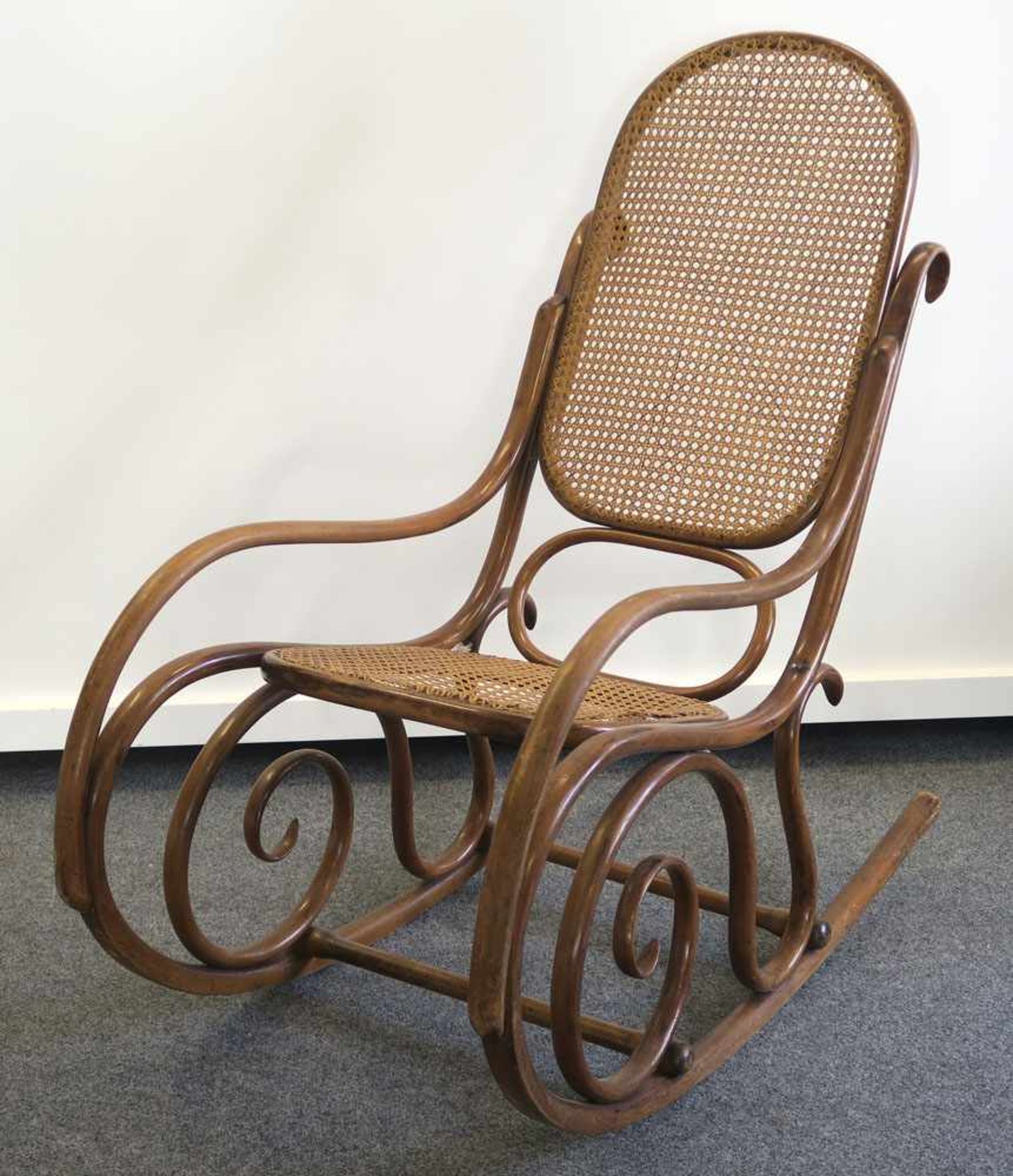 SchaukelstuhlIn der Art von Thonet. Bugholz, Rattangeflecht. Min. besch. H. 104 cm.