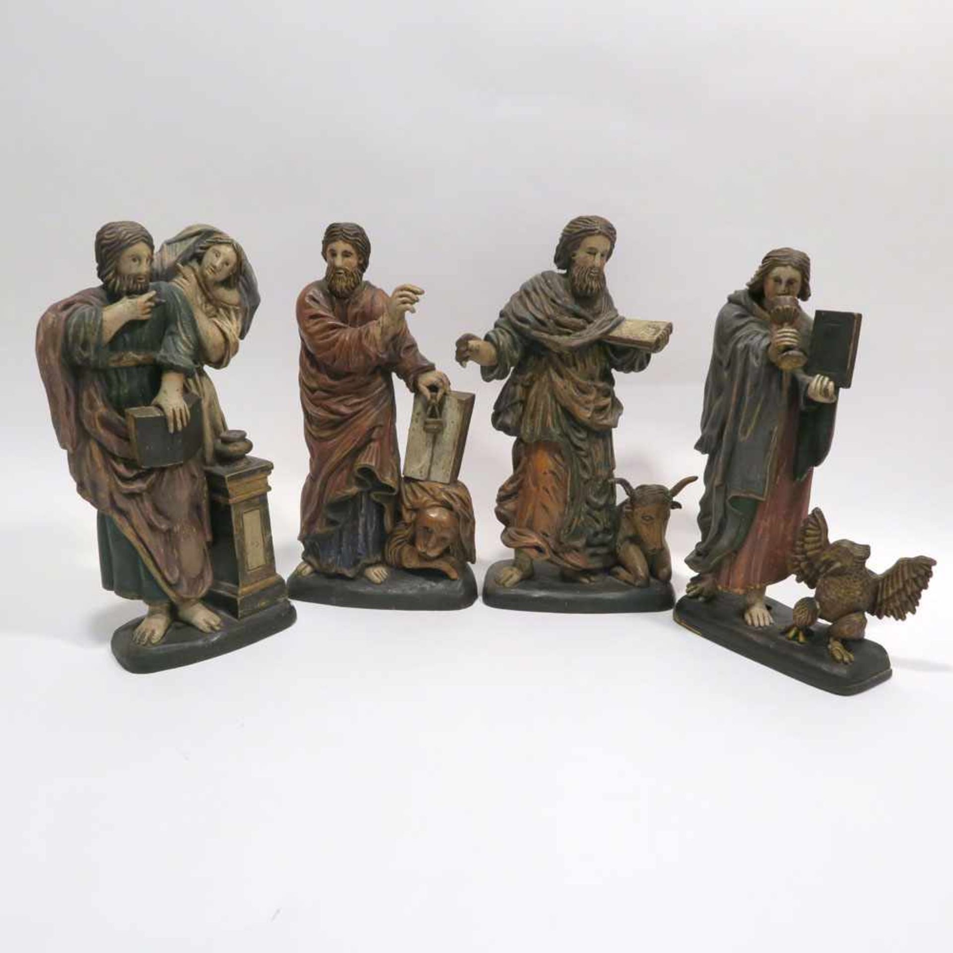 Die vier EvangelistenHolz, geschnitzt, Farbfassung. Tlw. rep., besch. H. 26,5 cm bis 28,5 cm.