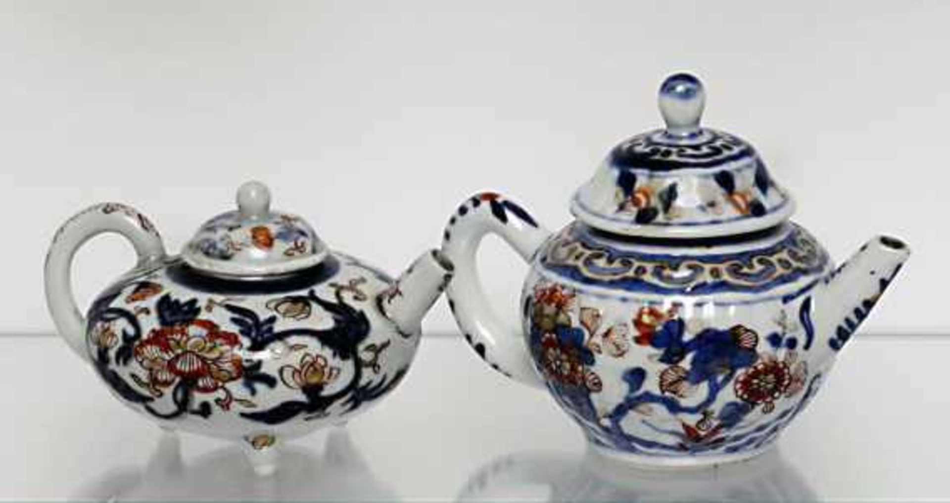 Zwei Imari-TeekännchenChina, Qing Porzellan. Florale Dekore in Unterglasurblau, Eisenrot und Gold.