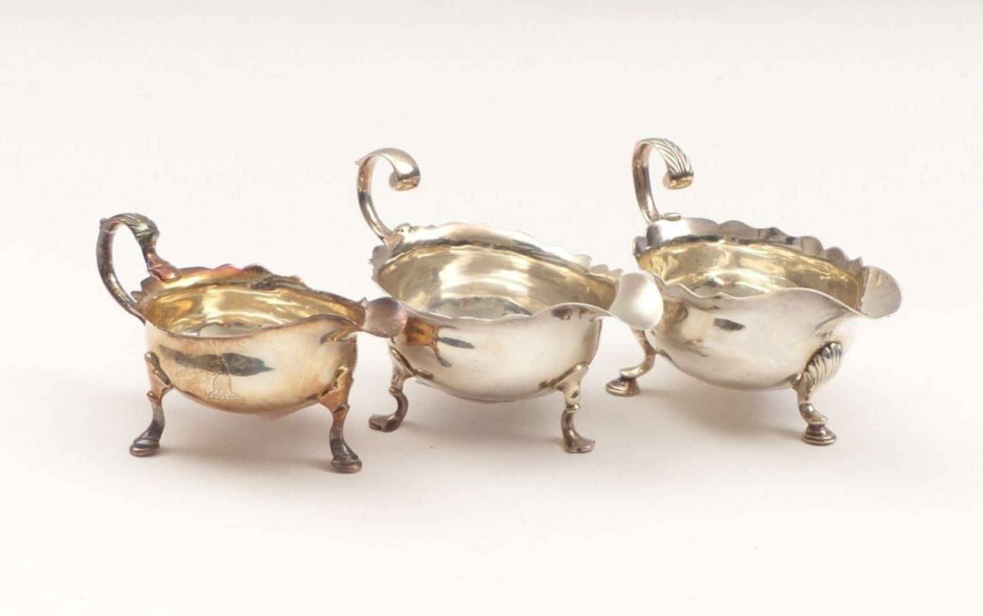 Three sauce boatsLondon, Georg II, Mid. 18th C.Silver, one with emblematic engraving. Hallmarks,