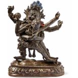 Dharmapala Begtse with Shakti in Yab-yumTibetA four-armed deity standing on a lungeing body on a