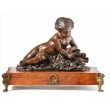 PuttoFrance, 19th centuryA full round putto lying on a natural pedestal with numerous flowers,