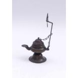 Oil lampProbably India, 19th c.With wick spout and holder for hanging up. Bronze. H. 17,2 cm.