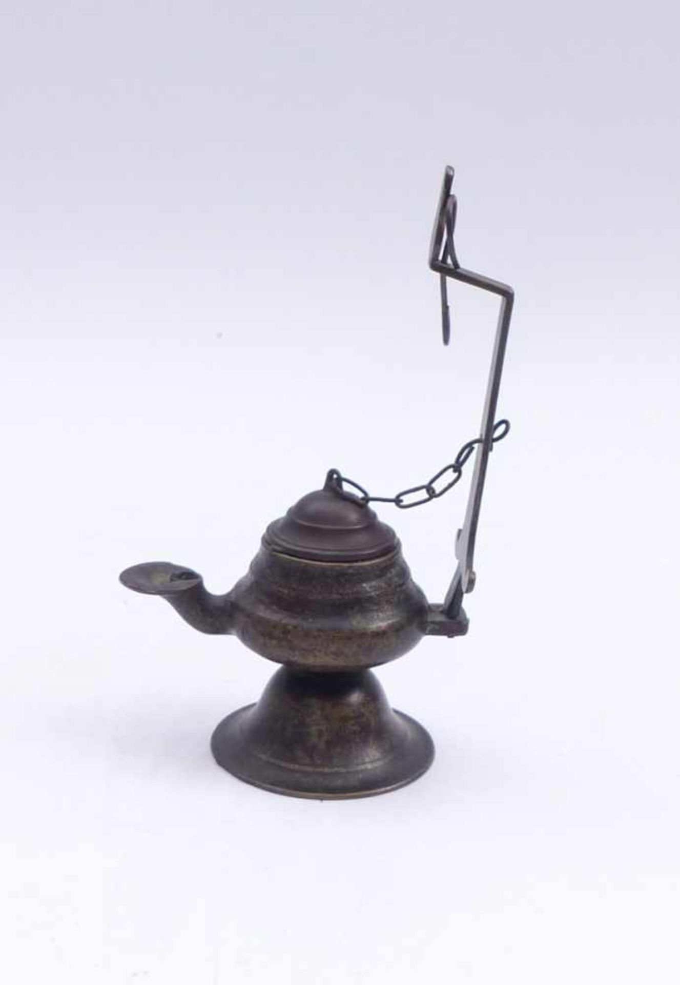 Oil lampProbably India, 19th c.With wick spout and holder for hanging up. Bronze. H. 17,2 cm.