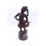 Temple dancerIndonesia, Mid 19th c.Standing figure in a moving dance pose on a pedestal decorated