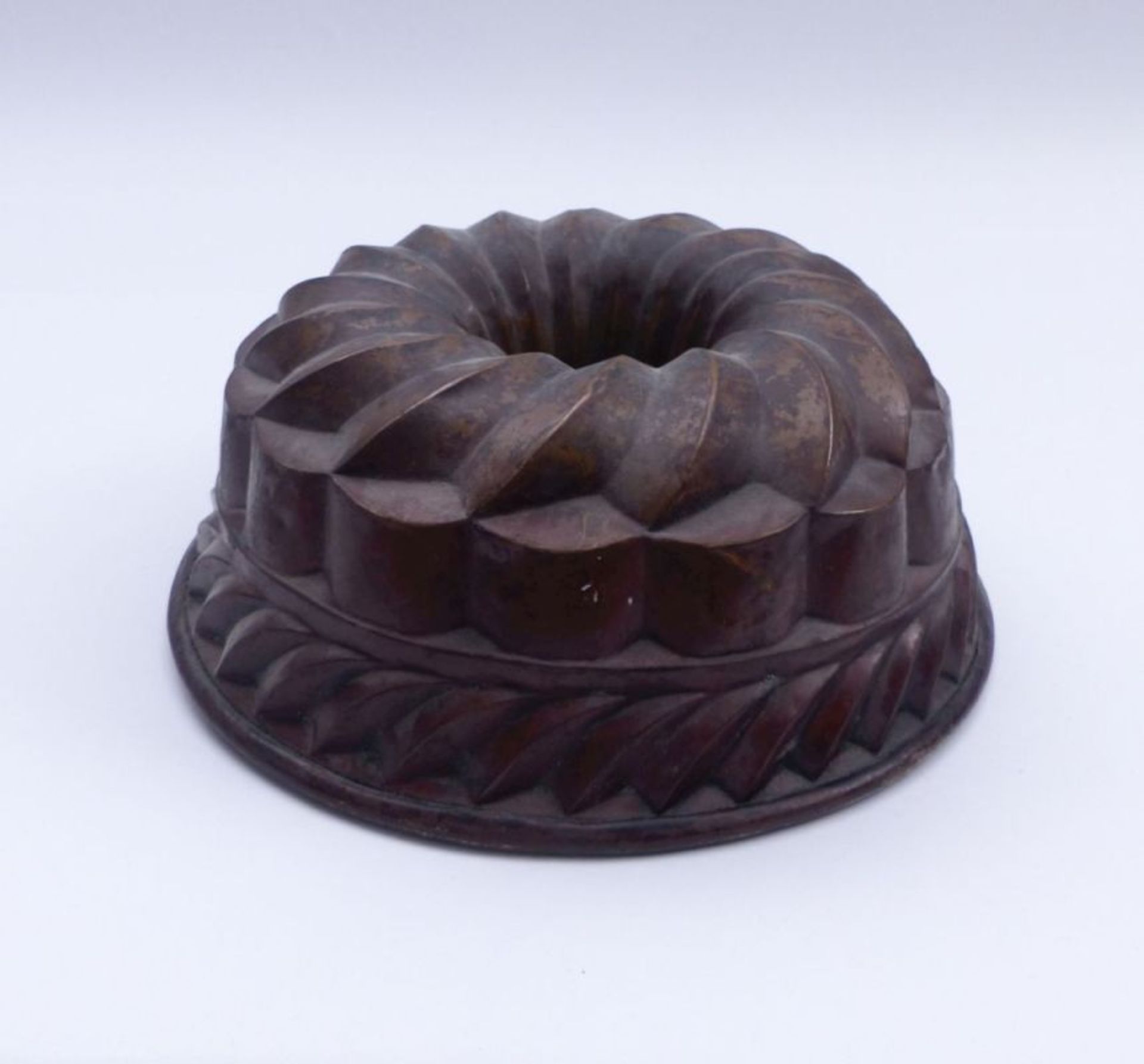 Baking mould19th centuryRound, multi-zone form with openwork inner tube, flanged rim. Copper with