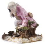 Boy catching a birdMeissen, 19th c.Cavalier kneeling on a square pedestal set with rocailles in