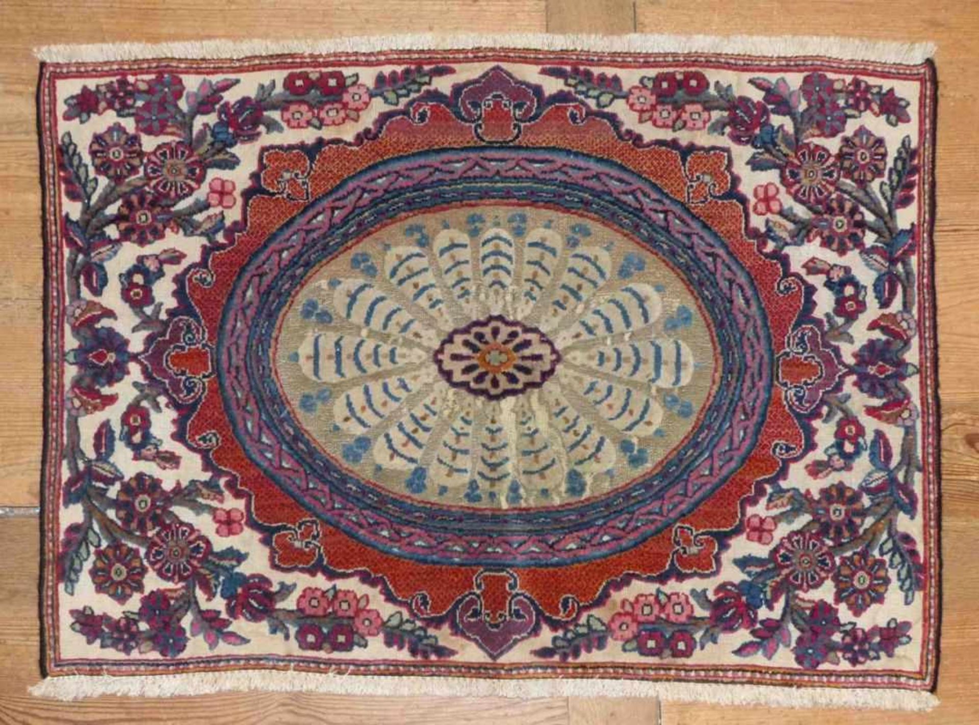 KeshanIran, 19th/20th c.Worked in relief, oval medallion surrounded by flower twigs. Wool. 97 x 72