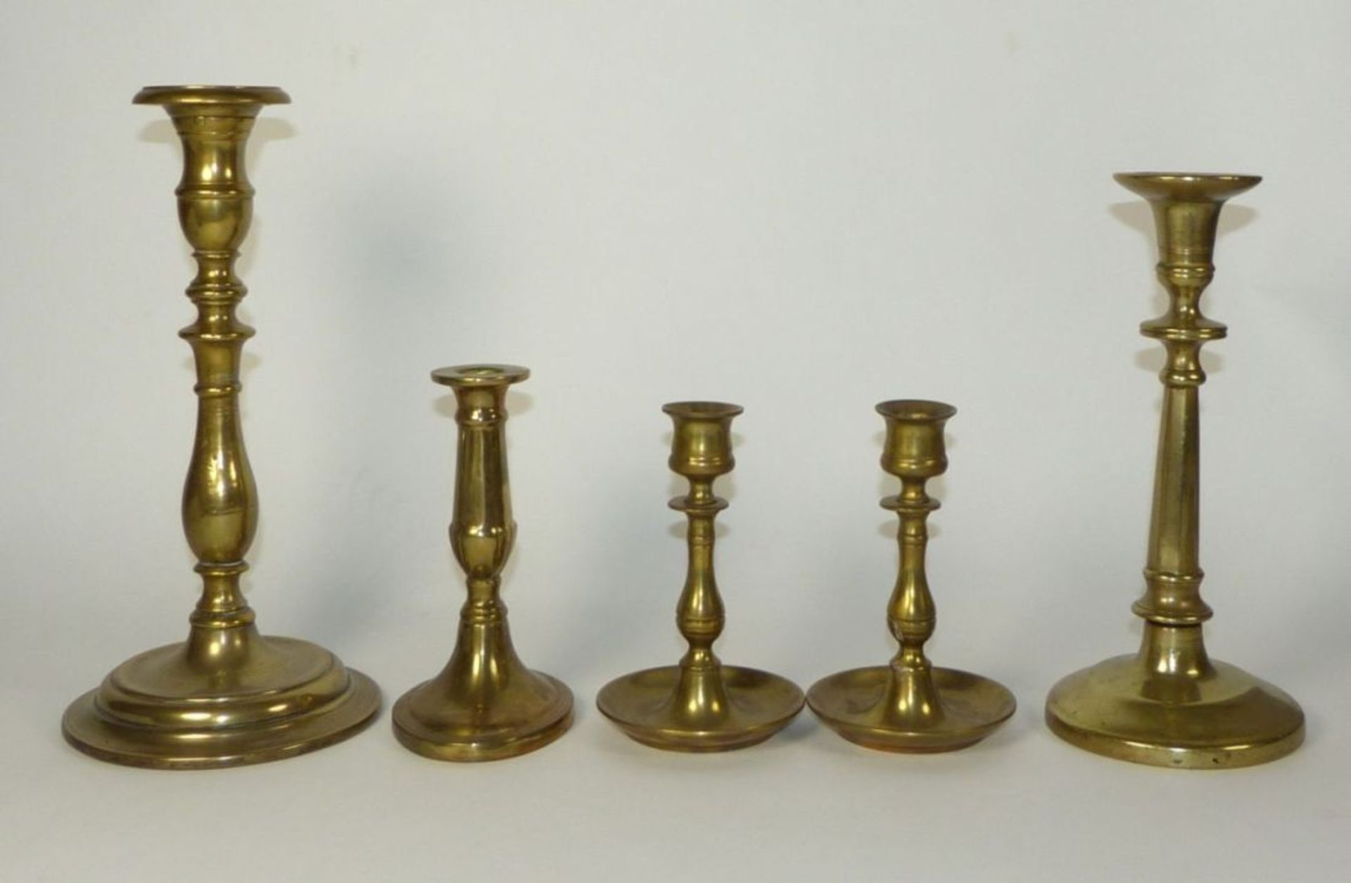 A collection of five candlesticks19th C.Brass. Partly marked ''England''. H. 14,5 to 28,5 cm. -