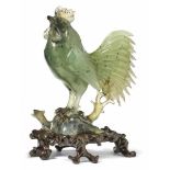 Figure of a rooster (Tori)Japan, 20th C.Green jade. H. 16,3 cm, with wooden base entire 19,5 cm.