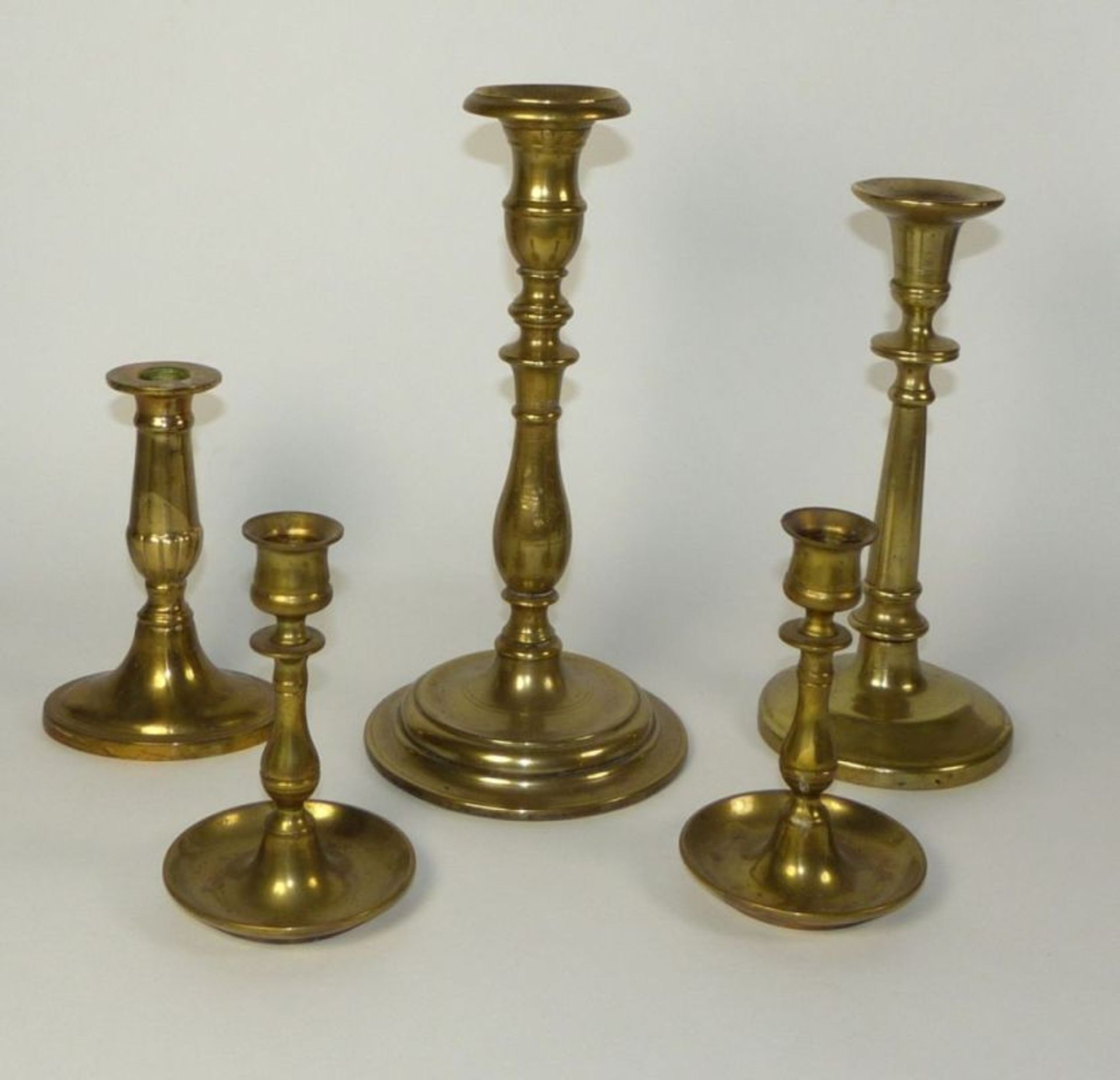 A collection of five candlesticks19th C.Brass. Partly marked ''England''. H. 14,5 to 28,5 cm. - - Bild 2 aus 2