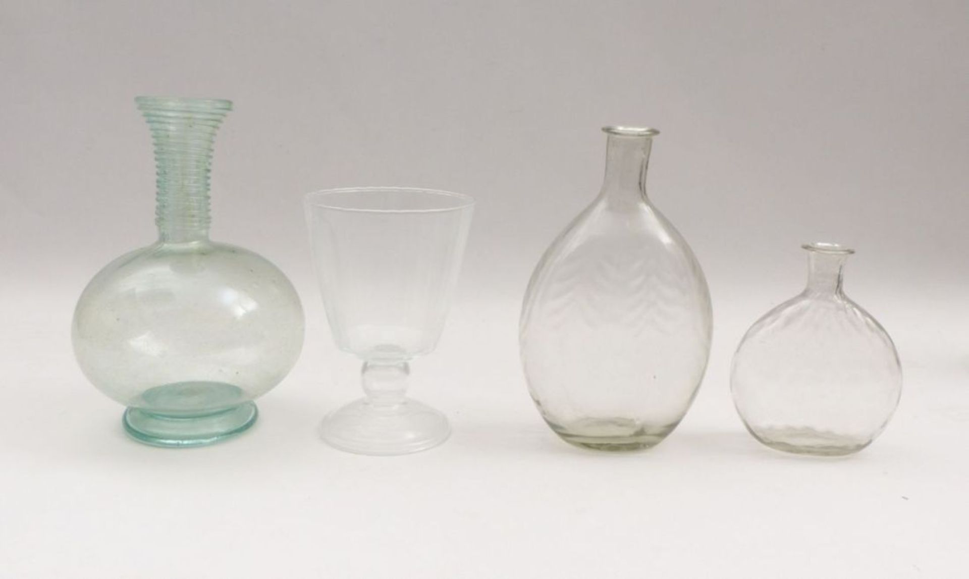 Four vessels18th C. and laterTwo bottles of blown colorless glass (G. 15 and 23 cm). A bottle of