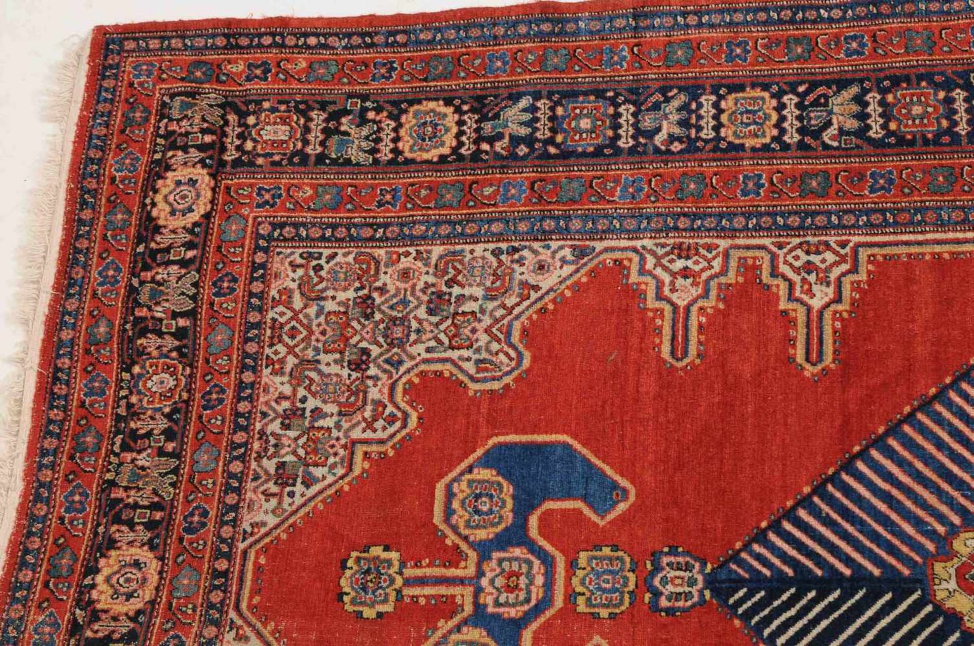 SenneW-Persien, um 1910. Im ruhigen ziegelroten Feld figuriert eine elegant angelegte blaue - Bild 5 aus 11