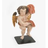 EngelsfigurItalien, um 1700. Holz geschnitzt, polychrom gefasst und tlw. vergoldet. Putto mit