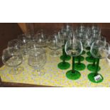 A set of fourteen Wine Goblets with green stems along with a quantity of brandy balloons.