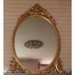 A fantastic mid 19th Century Timber Gilt Overmantle Mirror of oval form with swagged floral supports