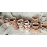 A large quantity of Terracotta Pots along with a pine potting table.